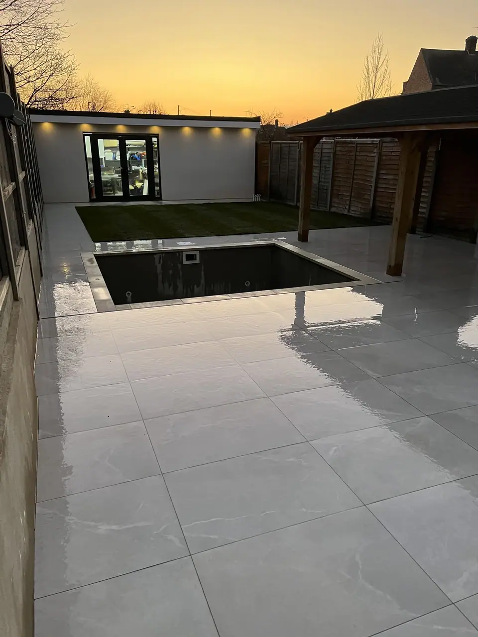 Pale garden paving and a garden building beneath an evening sky