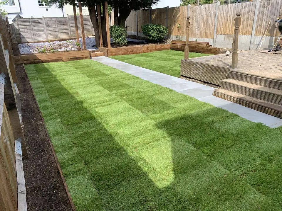 Striped garden lawn with pale stepping stones and timber boundaries
