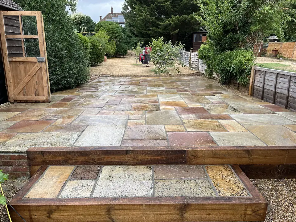Stone patio with warm colour variations and timber-edged steps