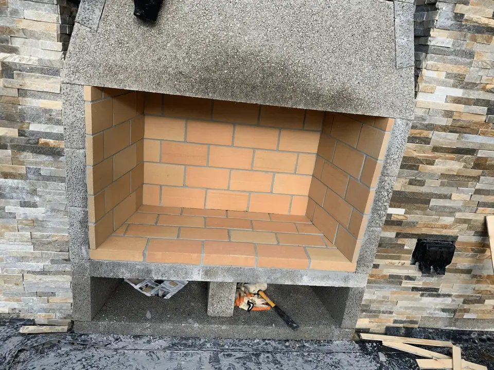 Brick-lined masonry feature and stone facing during construction